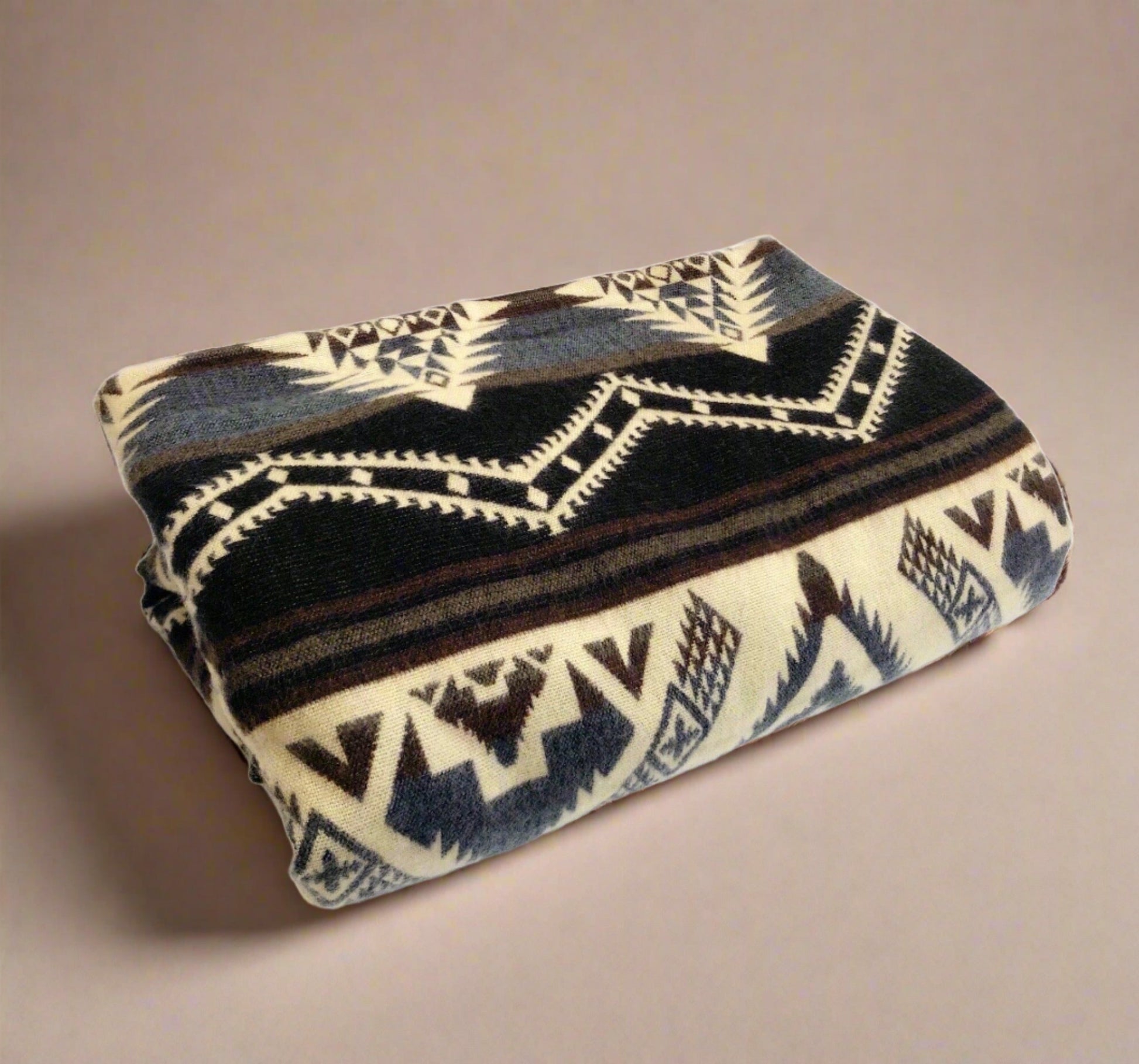 Handmade Southwestern alpaca wool blanket folded against neutral beige background
