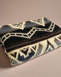Handmade Southwestern alpaca wool blanket folded against neutral beige background