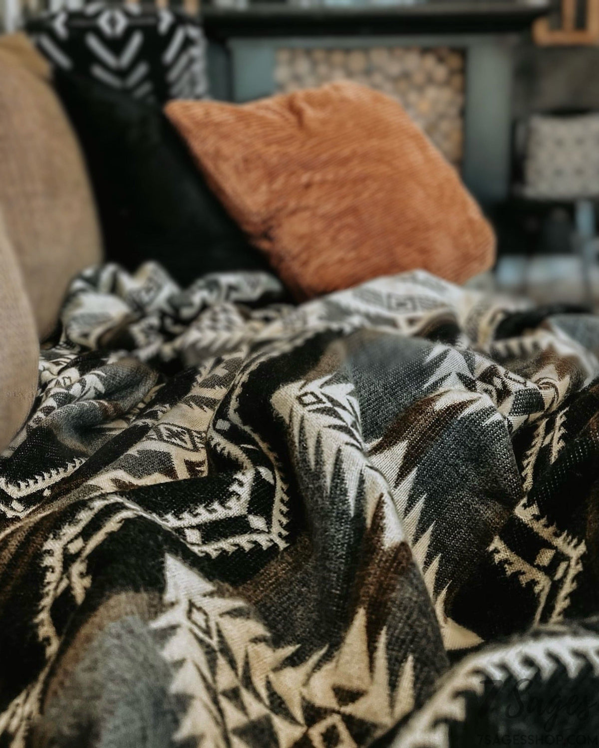 Gray and brown alpaca wool blanket on couch in a home with pillows in background